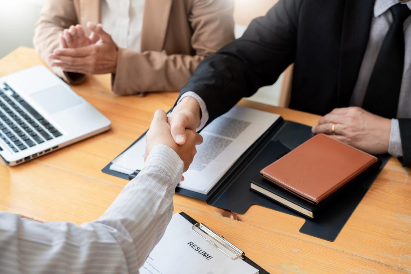 businessman employee candidate shaking hands with company leader
